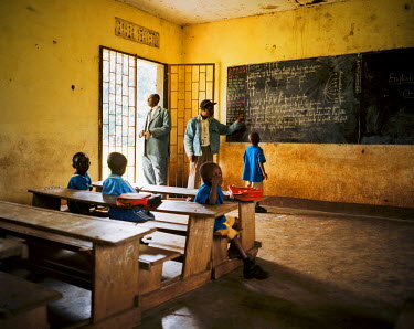 Guy Desire stands in the doorway of a classroom at the primary school where he is the head teacher. It is a small school in a military camp for the children of soldiers.