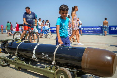 A boy touches a Stingray, a British manufactured torpedo used by the Romanian military, on display on the tourist promenade during the Navy Day. During the celebrations some navy ships and their weapo...