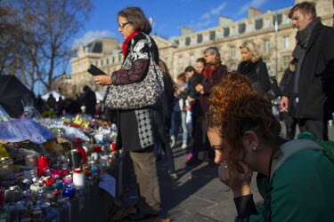 People contemplate at one of the many impromptu memorial sites created by the public at the sites of the atrocities and in the Place de la Republique as Paris struggles to come to terms with the event...