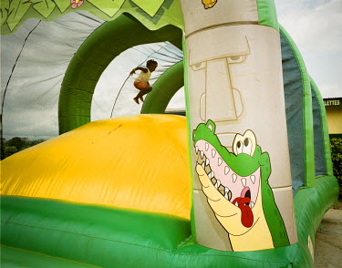 A little girl leaps inside a giant inflatable at an amusement park.