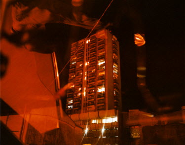 An apartment building seen through the window of a taxi.