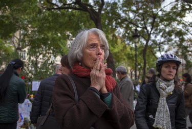 A woman at one of the many impromptu memorial sites created by the public at the sites of the atrocities and in the Place de la Republique as Paris struggles to come to terms with the events of 13 Nov...