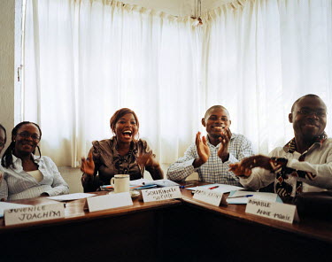 Participants applaud at the end of a role play during a training session for 'people's potential', particularly regarding women's opportunities and barriers that prevent their progress.