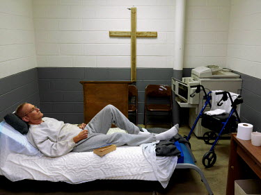 A sick inmate lies on a bed in the prison Chapel, which also serves as the facility's sick bay, in Putnam County Jail in Eatonton.