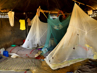 Inmates sleeping beneath mosquito nets, full of holes, at Mutukula Prison Farm, a low security facility housing 60 convicted prisoners. Inmates, who have reached the last phase of their sentence and h...