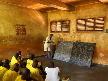 Inmates taking primary level biology lessons in Kirinya Main Prison. The inmate in white is on death row. The facility was built in colonial times for 336 inmates but now holds 898 convicts plus 24 on...