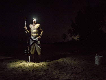 Paul Haas sets up his fishing rods at dusk. It is legal to sleep on the beach if you have rods out with bells on. Paul is homeless, and lives on the beach at Kihae. Hawaii has the highest per capita r...