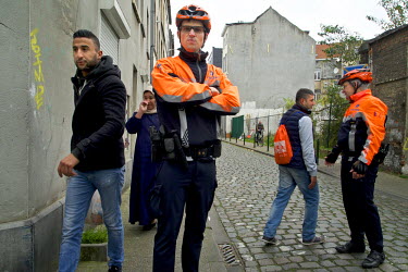 Police, in cycling uniforms, and passersby in Brussels' Molenbeek neighbourhood.