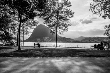 A father and child on the shore of Lake Lugano.