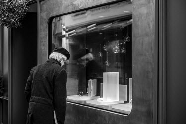 A man looks at the widow display of a jewellery shop.