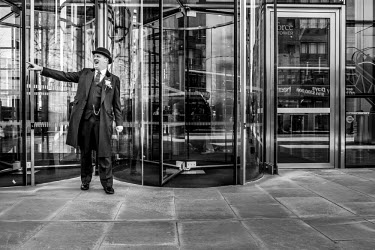 A doorman at the entrance to an office building in the City of London.