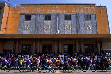 Cyclists pass the Art Deco Roma cinema during a street race. Both cycle racing and Art Deco architecture were introduced during the colonial era. Art Deco continued to flourish into the 1960s as local...