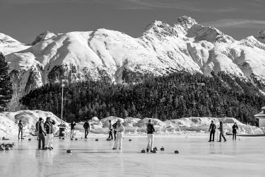 Hotel guest play games of curling on an artificial frozen lake.