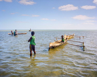 Two young boys, having helped their father and uncle to load the dugout, now watch them to the lagoon's boundry to fish. Fishing is a tradition for the Vezo people but now they make a living by farmin...