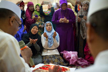 On the occasion of the imam Habib Hussin Mulachela's birthday member of his congregation gather for a feast after he has given a speech about the Koran in a small mosque in a wealthy suburb of Jakarta...
