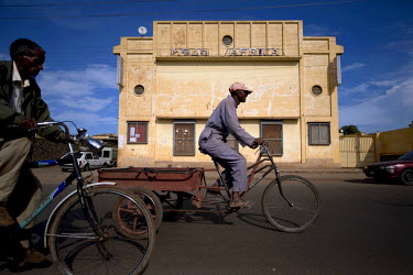 Cyclists pass the Cinema Africa. The city is a showcase of 1930s Italian Art Deco architecture. Initially created by colonial-era Italians, the style continued to flourish in the 1960s as local archit...