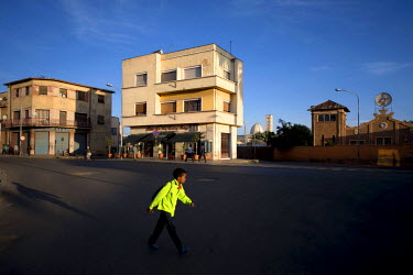 A boy walks past a building of the former Palazzo Lazzarini. Built in 1937 by architect Roberto Cappellano.  Asmara is a showcase of 1930s Italian Art Deco architecture. Initially brought to the regio...