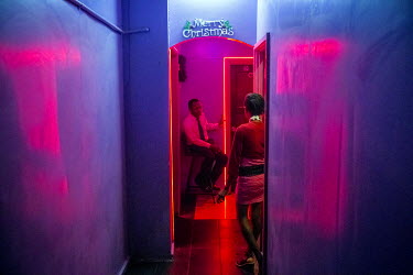 A security guard at the Pacific Leisure nightclub watches a member of 'PNG Drag Queens' gay group coming out of the female toilet.