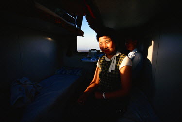 A Muslim Uighur girl, travelling back home after her studies in the distant capital, in her compartment aboard train during the 58 hour train ride from Beijing to Urumchi, in China's north-western Xin...