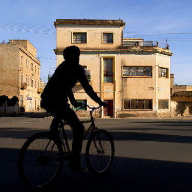 A cyclist passes an Art Deco style villa built in 1956 by architects Mario Fanano and Arturo Mezzedimi. Asmara is a showcase of 1930s Italian Art Deco architecture. Initially brought to the region by...