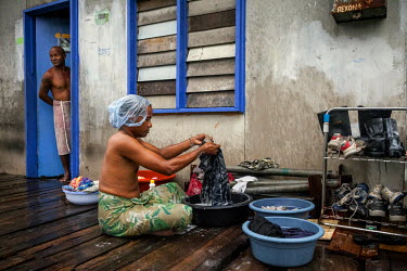 Haraga 'Speedy', 35, doing his laundry. A gay man from Hanuabada/Elevala village, considered one of the few places in PNG where gay men can live in safety. Male homosexuality is prohibited according t...