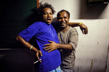 Haraga 'Speedy' and a friend, Sqye, hug each other at a party. Haraga, 35, is a gay man from Hanuabada/Elevala village, considered one of the few places in PNG where gay men can live in safety. Male h...