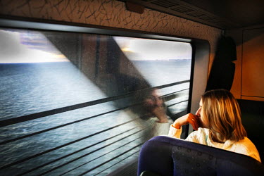 A woman sits on a train as it crosses the Oresund Bridge which connects the Danish capital of Copenhagen with teh Swedish city of Malmo. On Monday 4 January 2016, Sweden passed a law which requires pe...