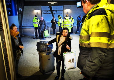 A police officer checks peoples' photo IDs as they board a train going from Copenhagen airport to Malmo in Sweden. On Monday 4 January 2016, Sweden passed a law which requires people wanting to enter...