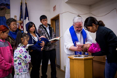 Pastor Marvin Jonasen baptises a child at the Shishmaref Lutheran Church, the only church in the town. Shishmaref is a barrier island with a population of less than 600 Alaska native Inupiaq people lo...