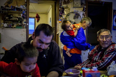 A family spend time in their living room in Shishmaref, a barrier island with a population of less than 600 Alaska native Inupiaq people located 30 miles south of the Arctic Circle. The island is thre...