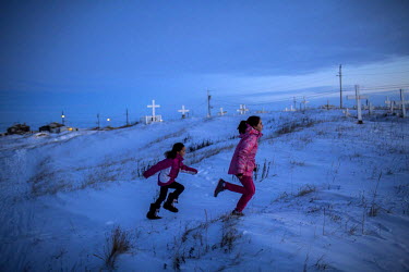 Children play near the the town's cemetery outside the town's only church. Shishmaref is a barrier island with a population of less than 600 Alaska native Inupiaq people located 30 miles south of the...