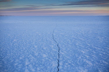 A crack in the ice that covers the Shishmaref Inlet, a lagoon on the west coast of Alaska. The frozen lagoon provides the residents of Shishmaref with access to the mainland and allows them to go furt...