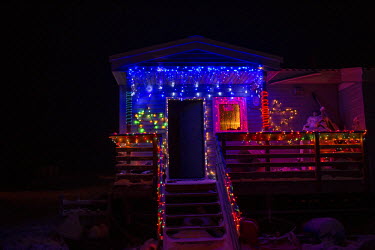 A house decorated with Christmas lights and decorations. Shishmaref is a barrier island with a population of less than 600 Alaska native Inupiaq people located 30 miles south of the Arctic Circle. The...