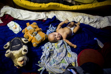 Two month old Pancho lies on a bed at the family home. Shishmaref is a barrier island with a population of less than 600 Alaska native Inupiaq people located 30 miles south of the Arctic Circle. The i...