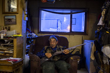 74 years old Clifford Wayiouanna with his hunting rifle at his home in Shishmaref, a barrier island with a population of less than 600 Alaska native Inupiaq people located 30 miles south of the Arctic...