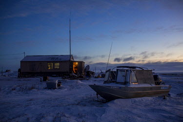 A boat lies on the frozen sea until released by the spring thaw. Shishmaref is a barrier island with a population of less than 600 Alaska native Inupiaq people located 30 miles south of the Arctic Cir...