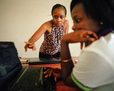 Khadidiatou Nakoulima, 28, the co-founder and manager of private health care company NEST, shows receptionist Benedicta how to use the company's monitoring and management software. Khadidiatou establi...
