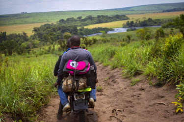 Bank employees travelling by motorbike ride through remote Bandundu province. A team from the bank took to the road for several weeks to travel the remote region in order to pay state employees and ci...