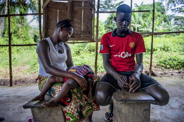 Ebola survivors Finda Mayamba (L) and Sorie Kamara, with their child, wait to see the doctor during a MSF outreach mission the village of Mabekoh. Many survivors of Ebola still suffer from physicial,...