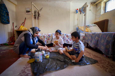 Thirty four year old Jihan eats a meal with her sons Ahmed and Mohammad aged five and seven in the Lavrio refugee camp.  They left Damascus with Jihan's husband Ashraf, to escape the conflict. Jihan i...
