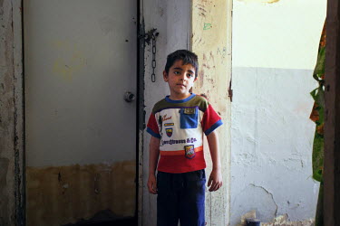 Five year old Ahmed stands in front of the community toilet in the Lavrio refugee camp. The physical conditions in the camp resemble a slum.  Thirty four year old Jihan left Damascus with her sons Ahm...