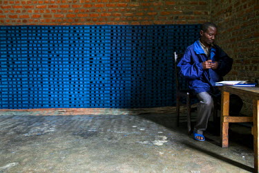 A worker at the Savonnerie Industrielle de Butembo (SAIBU) sits beside a stack of blocks of its main product, blue bars of soap. Bad roads and insecurity means the company generally can only sell its...