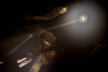A miner beneath ground in a coal mine. The 32 miners work eight hour shifts but the working conditions are tough. They breath in dust while crawling through the low tunnels, many end up with disabilit...