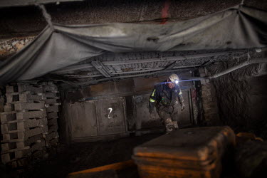 A miner beneath ground in a coal mine. The 32 miners work eight hour shifts but the working conditions are tough. They breath in dust while crawling through the low tunnels, many end up with disabilit...