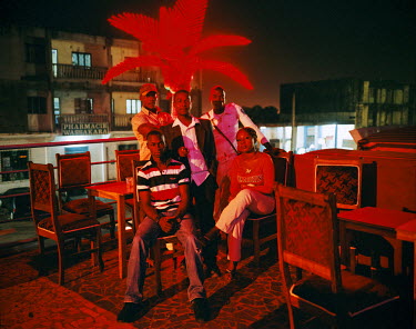 The managers of a bar popular with middle class Ivorians sit on the roof terrace of the building before customers arrive.