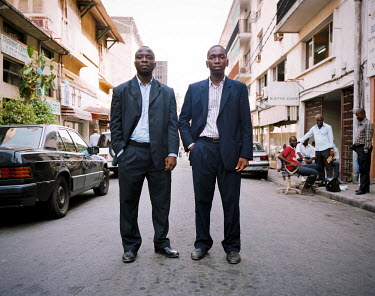 Two middle class businessmen stand in front of their office building in the Plateau quarter of Abidjan.