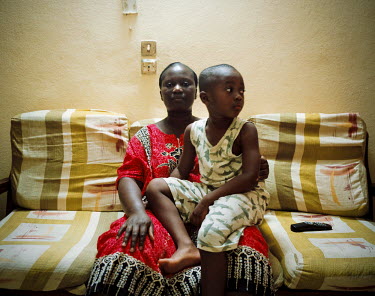 Ms Coulibaly poses in her apartment with her only son. She comes from a farming family near Yamoussoukro. Her diploma allowed her to find a job in a telephone company and improve her standard of livin...