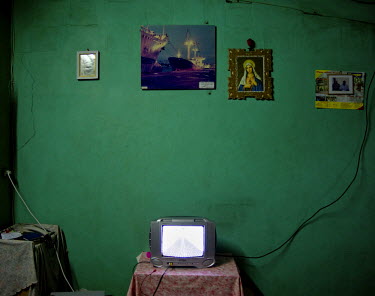 A small television stands on a table in a working class apartment in the port of Abidjan.