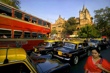 A double-decker bus and Hindustan Ambassador taxis (modelled on the Morris Oxford) outside Victoria train station.