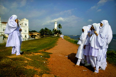A group of Muslim girls pose for a photo on the sea front.